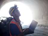 Construction worker with a laptop standing inside a tunnel. Levasil CB is excellent for use underground – especially in environmentally sensitive areas – thanks to its high ground consolidation and water sealing capabilities. 